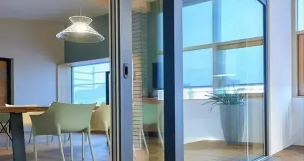 Grande porte coulissante vitrée ouvrant sur un séjour lumineux